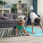 a woman and a child doing yoga in a living room